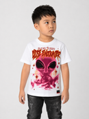 A young boy wearing a white t-shirt with a pink alien graphic and 'Secret Code: Close Encounter' text, paired with dark jeans, against a light gray background.
