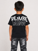 A child viewed from the back wearing a black t-shirt with a large white 'BLACK LABEL' graphic and distressed black jeans, set against a plain light gray background.