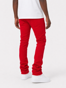 A person shown from the back wearing bright red slim-fit jeans with gathered side details, a white t-shirt, and white sneakers against a light gray studio background.