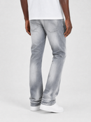 A person shown from the back wearing light gray washed denim jeans, a white t-shirt, and white sneakers against a plain light gray studio background.