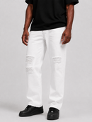 White distressed jeans with ripped knee details, worn by a model with a black t-shirt and black sneakers against a light gray studio background.