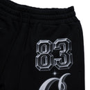 Close-up of black sweatpants with a large silver 83 graphic and a curved silver graphic below it, on a white background. By Fresh N Fitted.