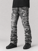 Distressed acid-wash gray jeans with ripped details, worn by a model with a black t-shirt and black sneakers against a light gray background.