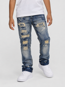 A person wearing distressed blue denim jeans with ripped details and white sneakers, shown from the waist down against a light gray studio background.