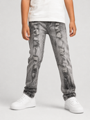 A child wearing gray acid-wash distressed jeans with ripped details, styled with a white t-shirt and white sneakers against a light gray studio background.