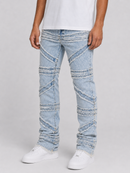Light wash blue denim jeans with diagonal stitched paneling and frayed detailing, shown on a model wearing a white t-shirt and white sneakers against a light gray studio background.