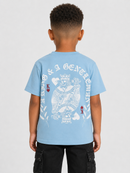 A child model shown from the back wearing a light blue t-shirt with a large white graphic print of a crowned king and the text 'A KING & A KING'. The child is also wearing black cargo pants against a light gray studio background.