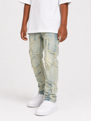 A child wearing light-wash distressed denim jeans with ripped patches, a white t-shirt, and white sneakers, shown from the waist down on a light gray studio background.