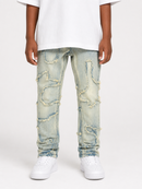 A person wearing light-wash distressed denim jeans with ripped details, paired with a white t-shirt and white sneakers, shown from the waist down on a light gray studio background.