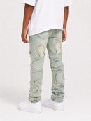A child wearing light-wash distressed denim jeans with ripped details and frayed edges, paired with a white t-shirt and white sneakers, shown from the back against a light gray studio background.
