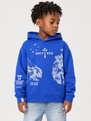 A young boy wearing a bright blue hoodie with white graphic prints and text, paired with light-wash jeans, photographed against a plain light gray studio background.