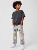 A child model wearing a faded charcoal gray t-shirt, distressed light blue and cream denim jeans, and white sneakers, standing against a light gray studio background. By Fresh N Fitted