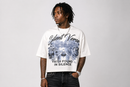 A man wearing a white graphic t-shirt with a black and blue winter scene and the text 'Silent Verse' and 'FAITH FOUND IN SILENCE', paired with dark jeans, against a light gray background. By Fresh N Fitted