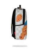 A backpack with a white and gray checkered pattern, featuring large illustrations of chocolate chip cookies and a blue accent, shown against a plain white background.