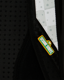 Close-up of a black textured fabric item with a white and gray patterned panel and a visible Sesame Street logo patch.