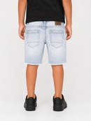 A child shown from the back wearing light-wash denim shorts with a frayed hem, a black t-shirt, and black sneakers against a plain light gray studio background.