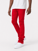 A person wearing bright red distressed skinny jeans with ripped details on the thighs and knees, styled with a white t-shirt and white sneakers against a light gray studio background.