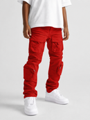 A person wearing bright red cargo pants with multiple flap pockets, styled with a white t-shirt and white sneakers against a light gray studio background.