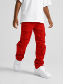 A child wearing bright red cargo pants with multiple flap pockets, styled with a white t-shirt and white sneakers against a light gray studio background.