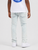 A person shown from the back wearing light-wash acid-wash jeans, a white tank top with a blue graphic, and white sneakers against a light gray studio background.