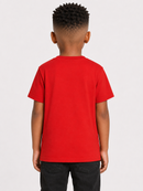 A child model shown from the back wearing a bright red short-sleeve t-shirt and black pants, photographed against a light gray studio background.