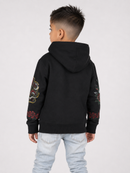 A child model shown from the back wearing a black hoodie with colorful embroidered dragon and rose patterns on the sleeves, paired with light-wash jeans, against a plain light gray background.
