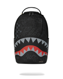 A black Sprayground Shark backpack with a stylized shark mouth graphic in red, gray, and white on the lower front, shown against a plain white background.