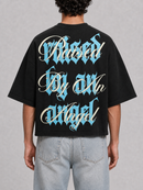 Black oversized cropped T-shirt by Silent Verse featuring the "Raised By An Angel" design, casual and stylish for everyday wear.