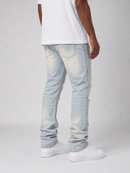 A person shown from the back wearing light-wash distressed jeans, a white t-shirt, and white sneakers against a light gray studio background.