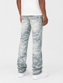 A person shown from the back wearing light-wash distressed denim jeans with a diagonal seam detail and white sneakers against a plain white studio background.