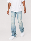 A person wearing light-wash blue distressed jeans with ripped details, paired with a white t-shirt and white sneakers, shown from the waist down on a light gray studio background.