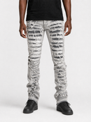 A person wearing distressed light gray jeans with heavy ripped detailing and frayed edges, paired with a black t-shirt and black sneakers, shown from the waist down on a light gray studio background.