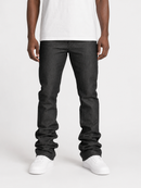 A person wearing dark charcoal gray slim-fit jeans, styled with a white t-shirt and white sneakers, shown from the waist down on a light gray studio background.